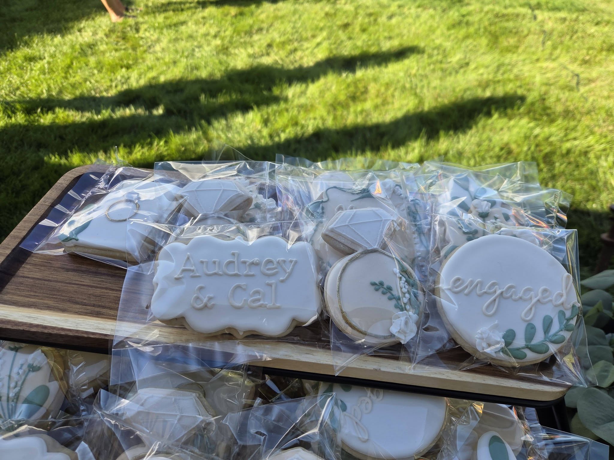 Decorated iced cookies in clear bags on a table outdoors