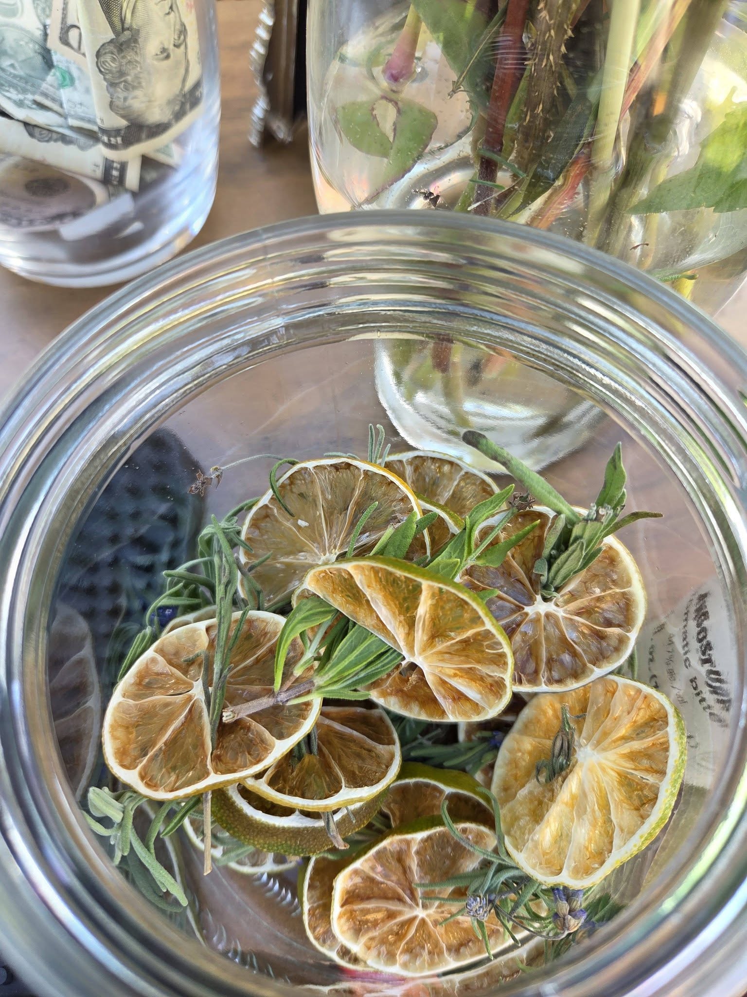 A glass jar filled with dried citrus wheels and herbs